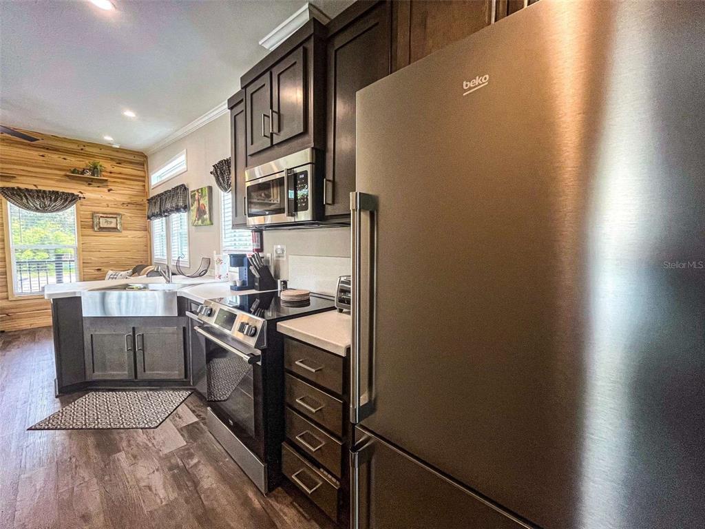 107 Long Hammock Drive River Ranch, FL 33867 - Photo 7 of 21 a kitchen with stainless steel appliances granite countertop a stove a sink and a refrigerator
