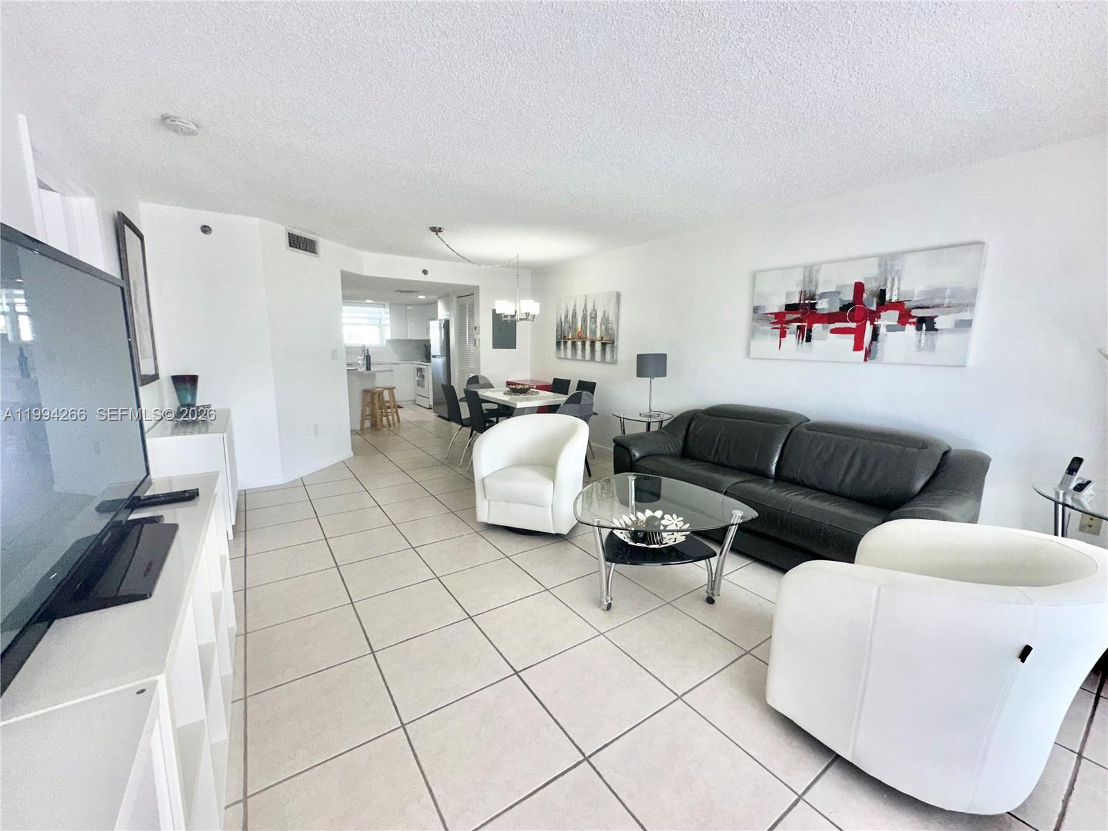 17801 North Bay Road, Unit 513 Sunny Isles Beach, FL 33160 - Photo 2 of 9 a living room with furniture and a floor to ceiling window