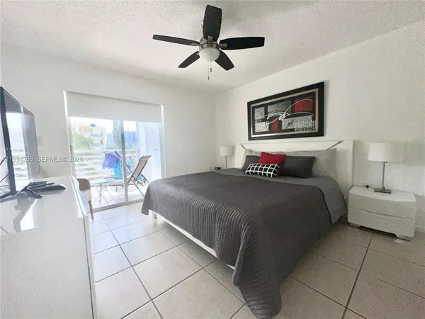 a bedroom with a bed a couch and a chandelier