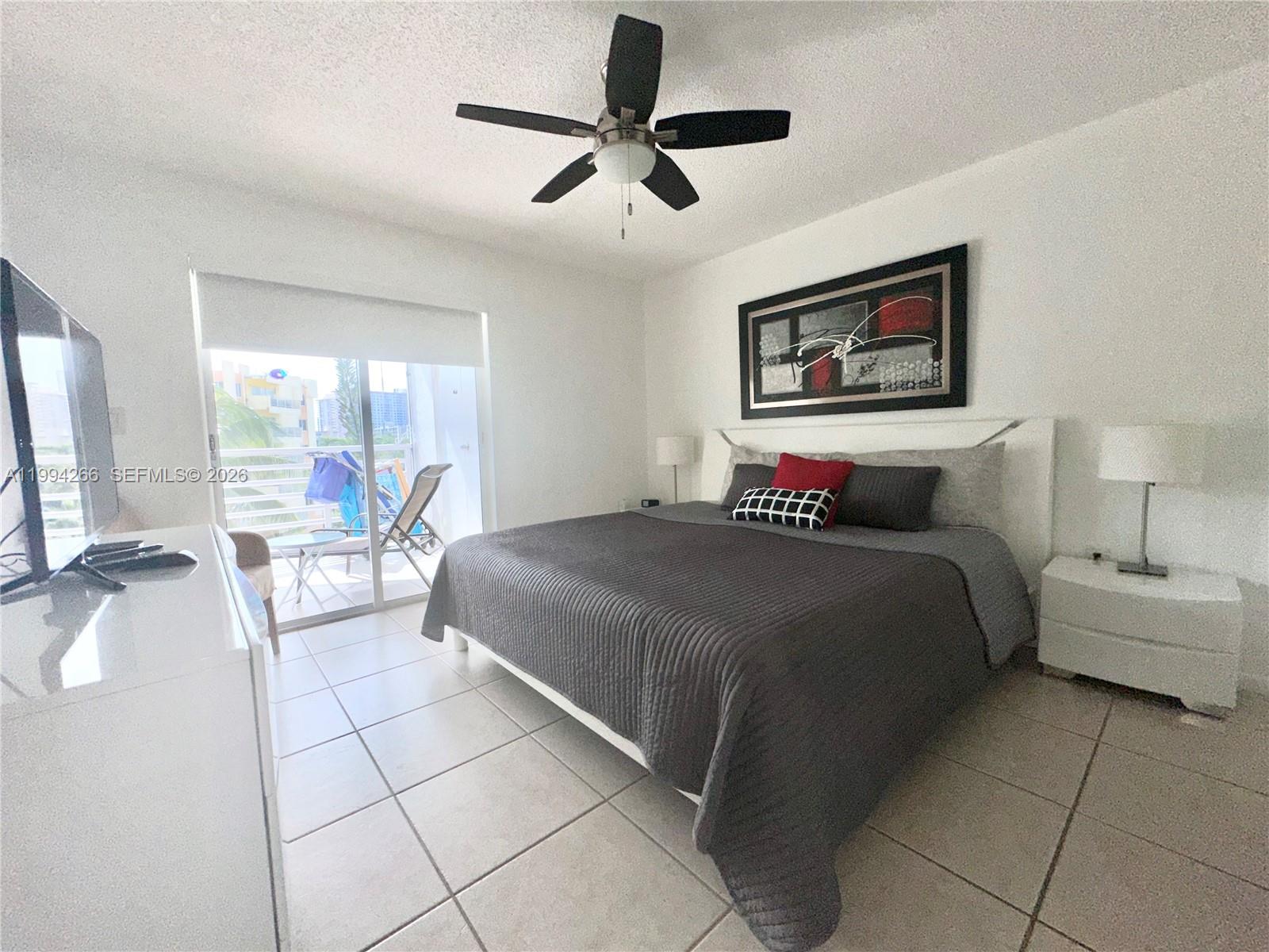 17801 North Bay Road, Unit 513 Sunny Isles Beach, FL 33160 - Photo 3 of 9 a bedroom with a bed a couch and a chandelier