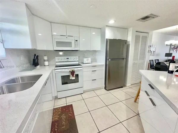 a kitchen with a sink a stove a refrigerator and cabinets