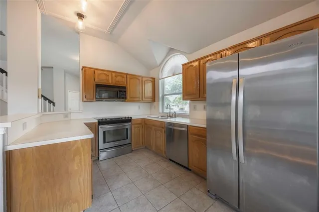 a modern kitchen with stainless steel appliances granite countertop a refrigerator and a sink