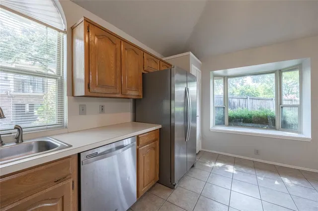 a kitchen that has a sink a stove and a refrigerator