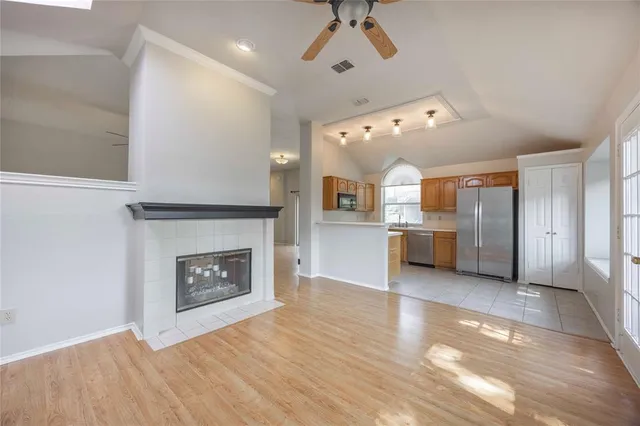 a open kitchen view with fireplace a stove and a window