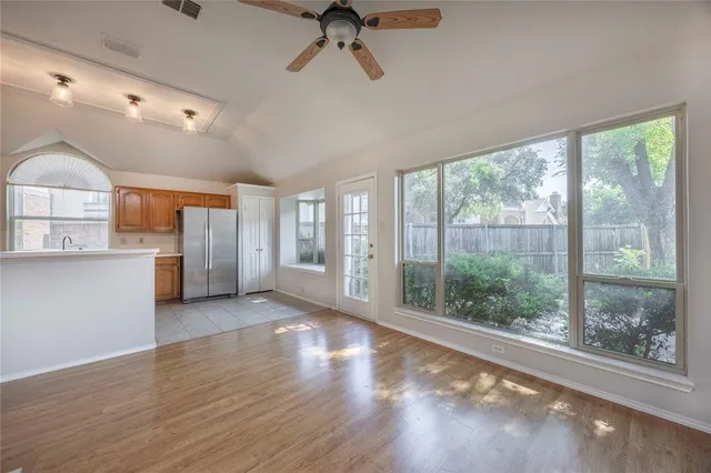 a view of a big room with wooden floor and windows