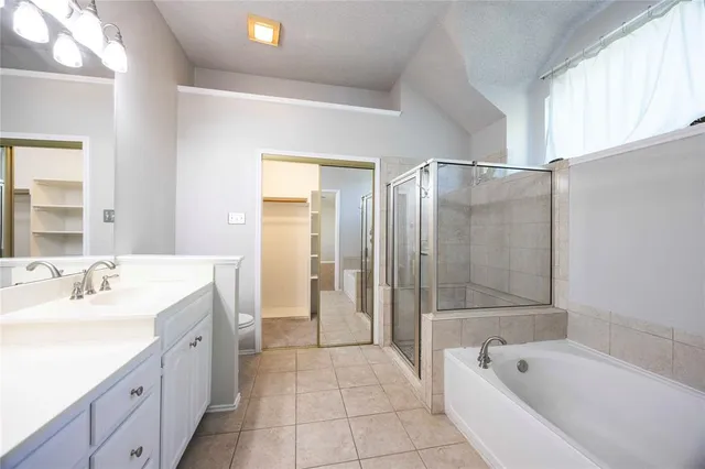 a spacious bathroom with a tub sink shower and mirror