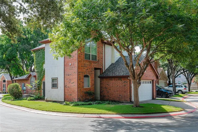 a front view of a house with a garden and trees