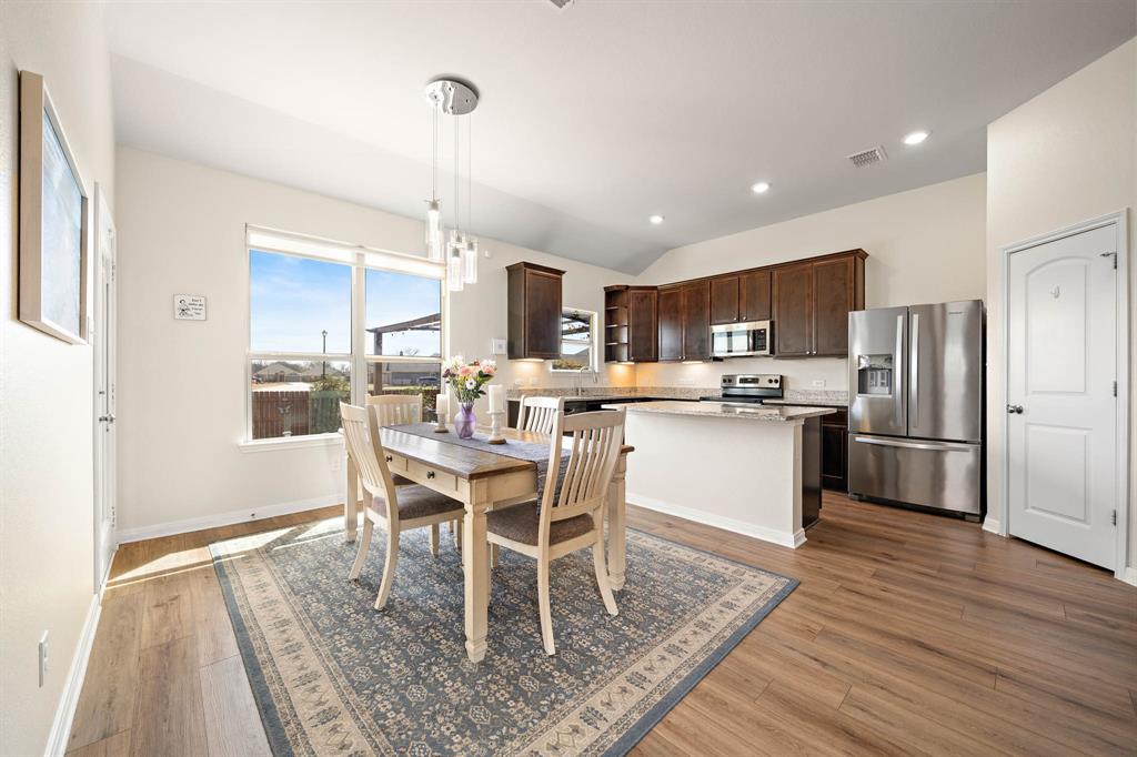4009 Bravo Ranch Road Waco, TX 76705 - Photo 13 of 34 a kitchen with stainless steel appliances granite countertop a table chairs and a refrigerator