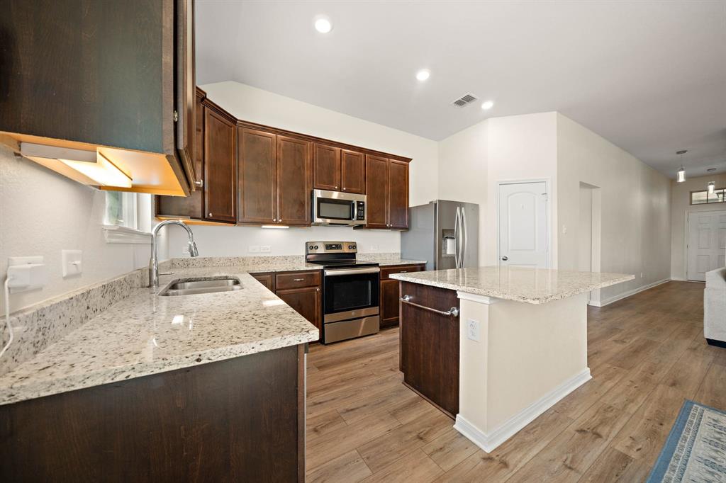 4009 Bravo Ranch Road Waco, TX 76705 - Photo 15 of 34 a kitchen with granite countertop a refrigerator stove top oven and sink