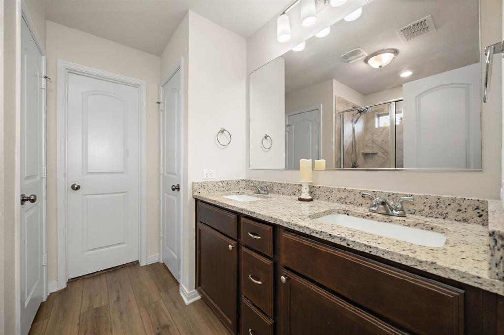 4009 Bravo Ranch Road Waco, TX 76705 - Photo 18 of 34 a bathroom with a granite countertop sink a large mirror and a