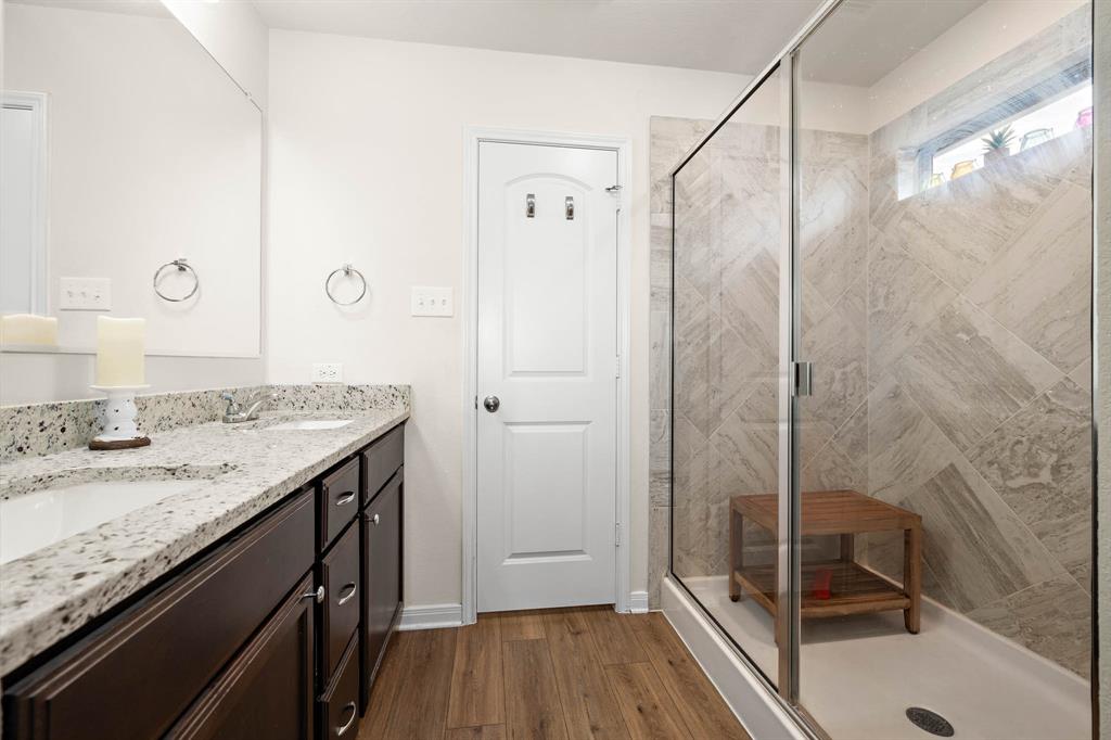 4009 Bravo Ranch Road Waco, TX 76705 - Photo 19 of 34 a bathroom with a granite countertop sink a shower and a mirror