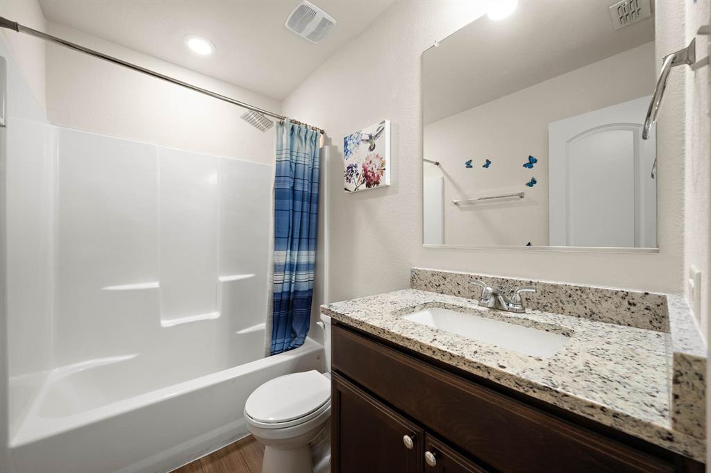 4009 Bravo Ranch Road Waco, TX 76705 - Photo 23 of 34 a bathroom with a granite countertop sink toilet and shower