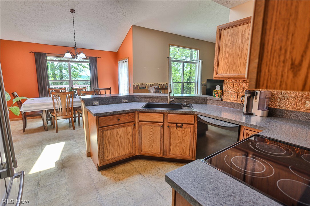 11154 Johnsford Road Southwest Beach City, OH 44608 - Photo 21 of 50 Kitchen featuring wood cabinetry, dark countertops, built-in electric cooktop, and an integrated sink