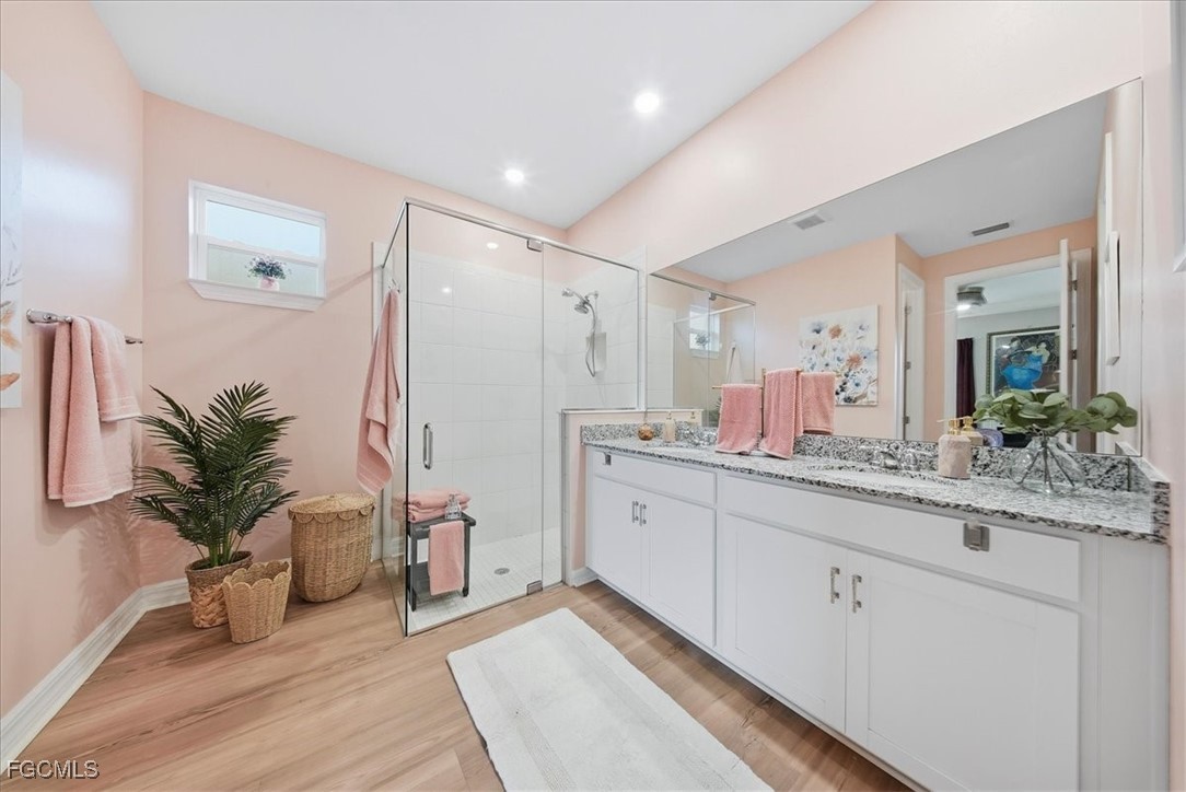 16128 Lotus Way Punta Gorda, FL 33982 - Photo 13 of 49 a spacious bathroom with a granite countertop sink a mirror and a potted plant