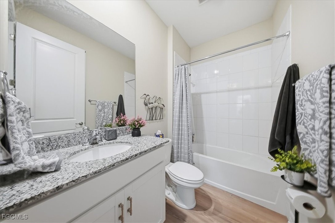 16128 Lotus Way Punta Gorda, FL 33982 - Photo 22 of 49 a bathroom with a granite countertop sink toilet a large mirror a bathtub and shower