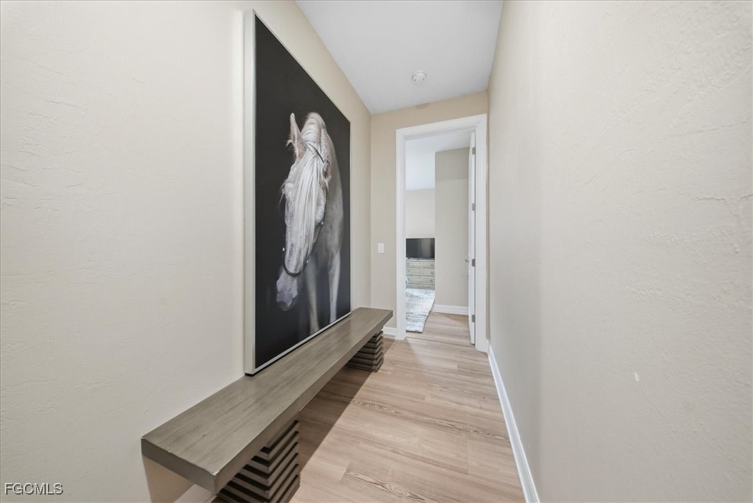 16128 Lotus Way Punta Gorda, FL 33982 - Photo 23 of 49 a view of a hallway with wooden floor