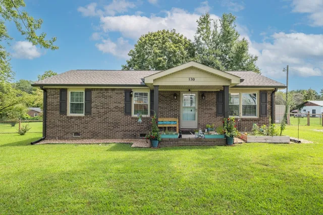 a front view of a house with a yard and porch