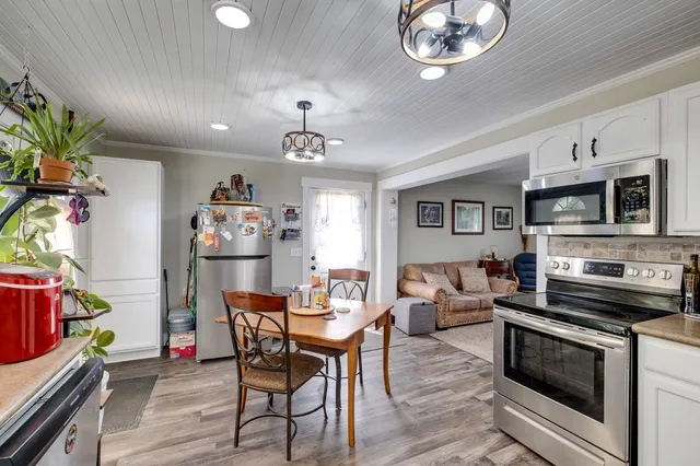 a view of a dining room with furniture and a kitchen