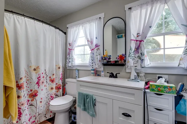 a bathroom with a sink mirror vanity and toilet