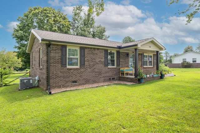 a view of a house with a yard and sitting area