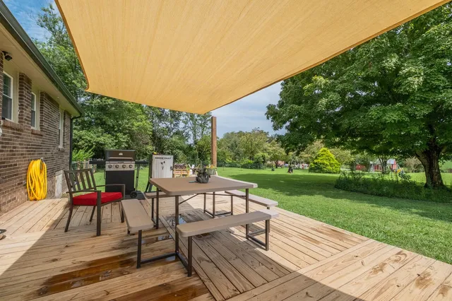a view of a patio with dining table and chairs with wooden floor and fence