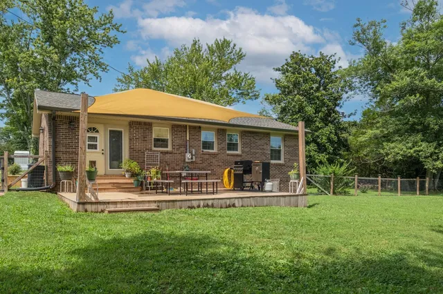 a view of a house with a yard and sitting area