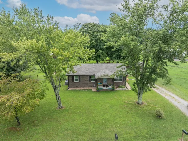 a view of a house with a yard and sitting area