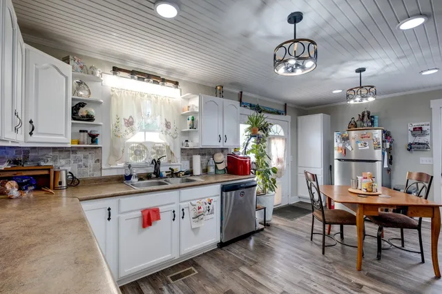 a kitchen with stainless steel appliances granite countertop a stove a sink dishwasher and cabinets with wooden floor