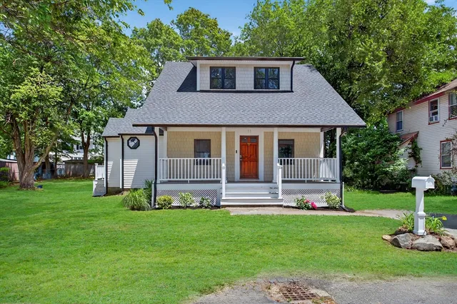a front view of a house with a yard and green space
