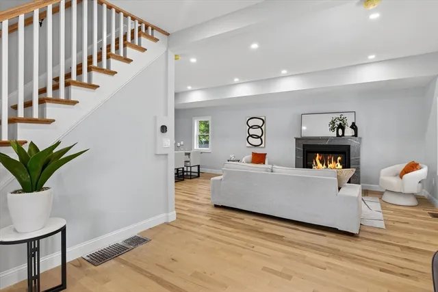 a living room with fireplace furniture and a wooden floor