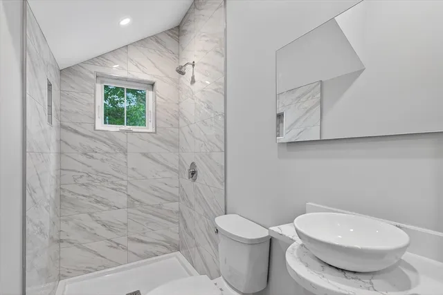 a bathroom with a toilet a sink and shower