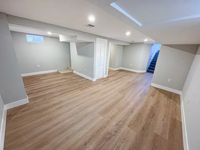 a view of empty room with wooden floor