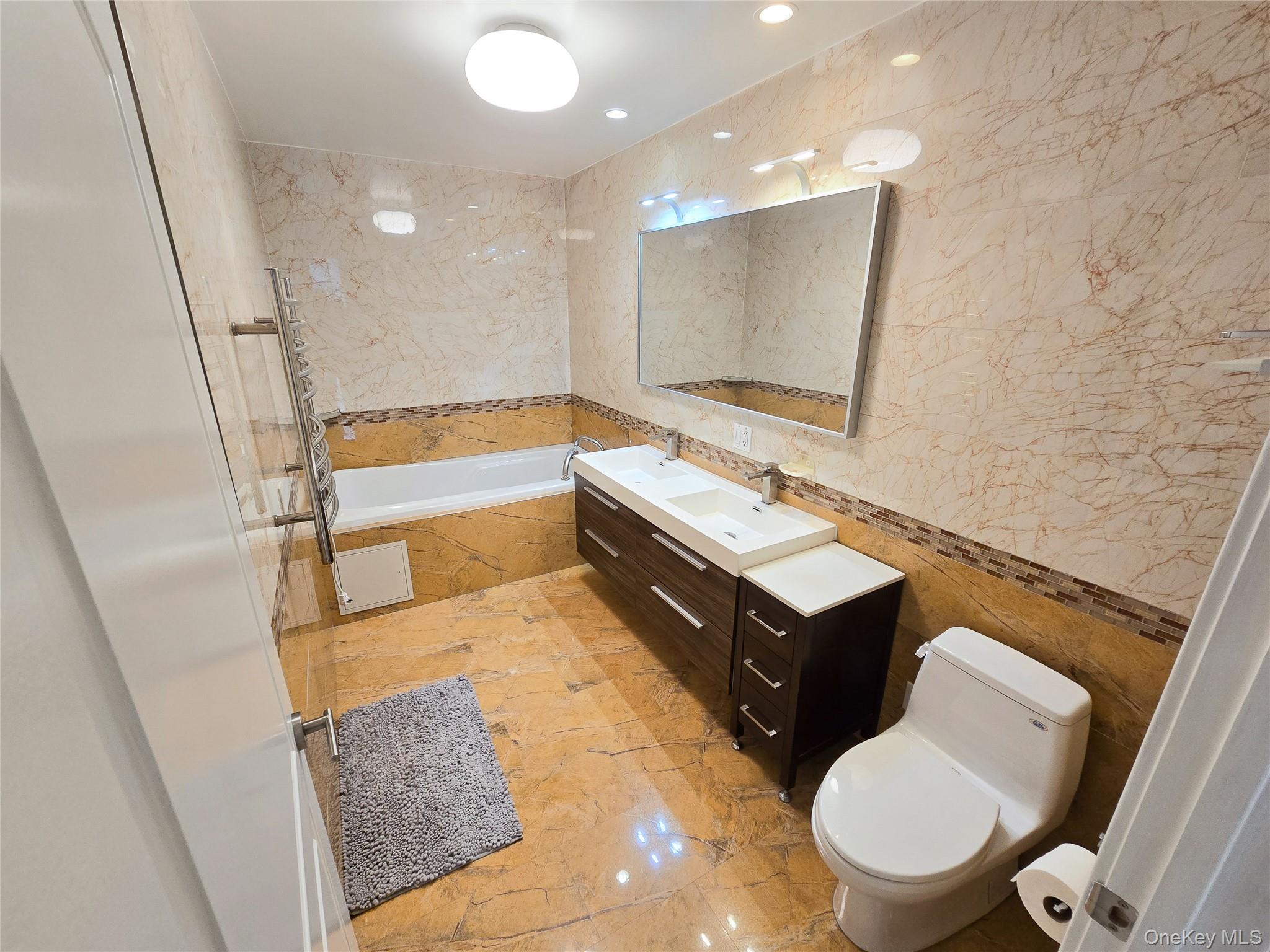 63-36 99th Street, Unit 5B Queens, NY 11374 - Photo 4 of 20 a bathroom with a sink mirror vanity and toilet
