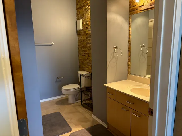 a bathroom with a granite countertop sink toilet and shower