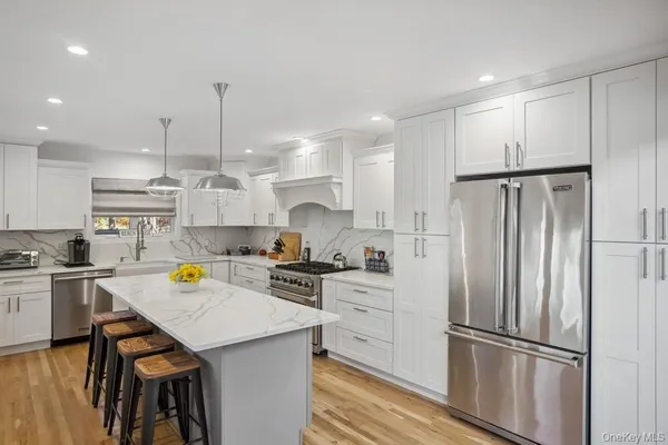 a kitchen with a refrigerator a sink and wooden floor