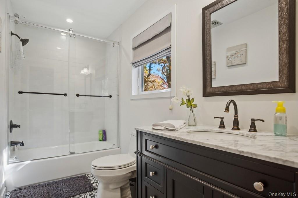 18 Park Circle Quogue, NY 11959 - Photo 16 of 25 a bathroom with a granite countertop sink a toilet a shower and a mirror