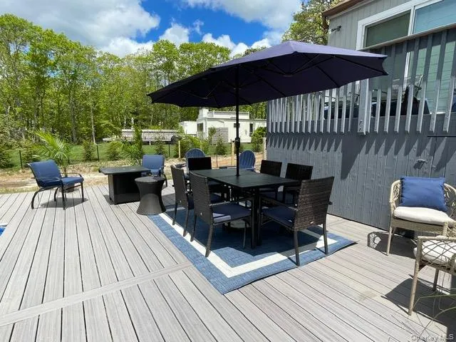 a view of a roof deck with table and chairs under an umbrella with wooden floor
