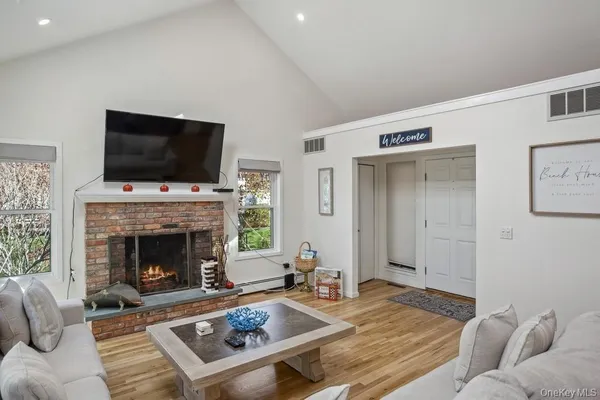 a living room with furniture a flat screen tv and a fireplace