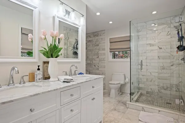 a bathroom with a granite countertop sink a toilet and a mirror
