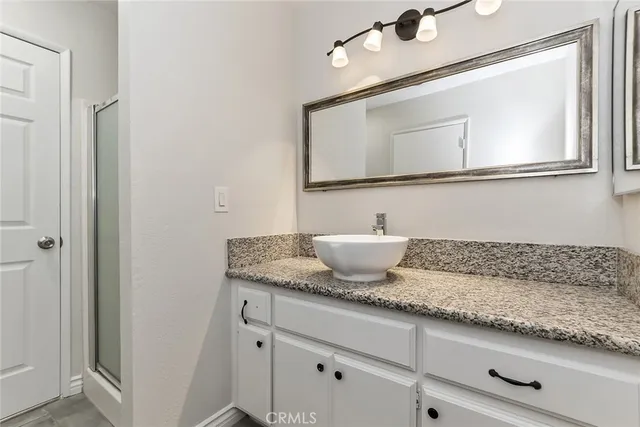 a bathroom with a granite countertop sink and a mirror