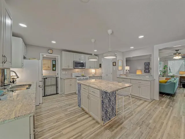 a kitchen with stainless steel appliances granite countertop wooden cabinets and sink