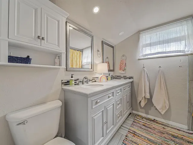 a bathroom with a sink a toilet and a mirror