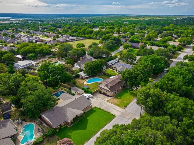 an aerial view of residential houses with outdoor space and trees