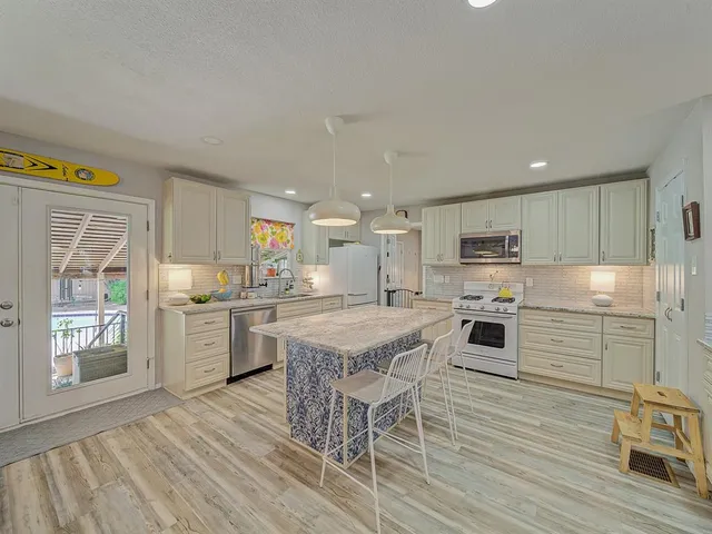a kitchen with a sink a kitchen island and stainless steel appliances