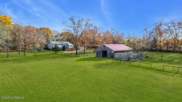 a view of a big house with a big yard and large trees
