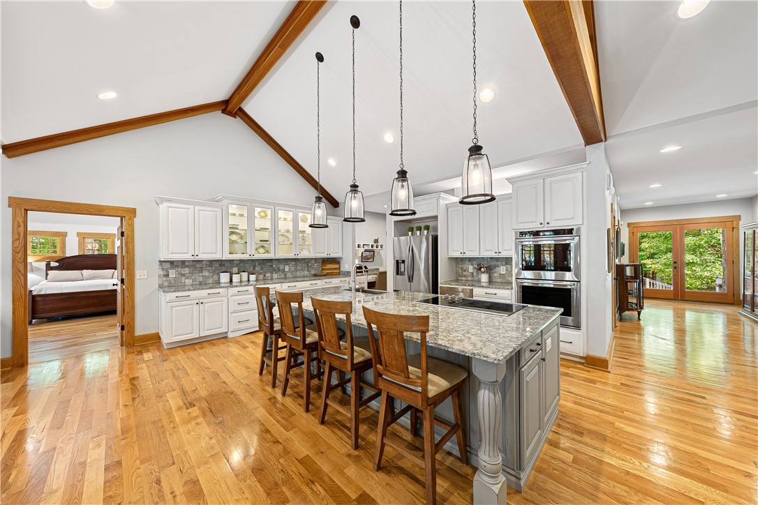 285 Bertha Allen Road Westminster, SC 29693 - Photo 11 of 50 Bright hardwood floors and vaulted ceilings elevate this open-concept chef's kitchen with a spacious granite island.