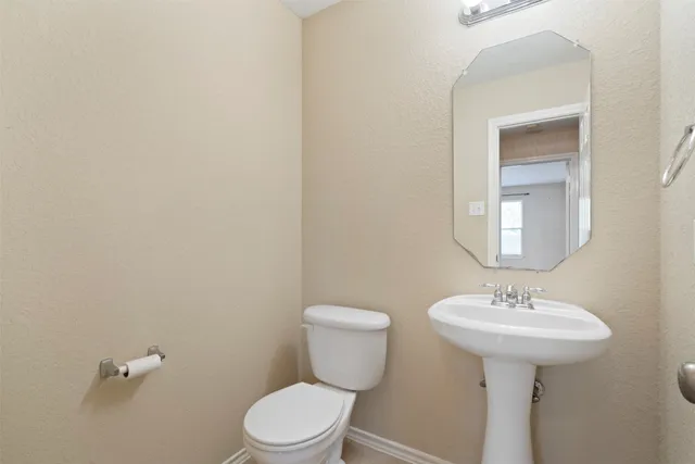 a bathroom with a sink a toilet and mirror