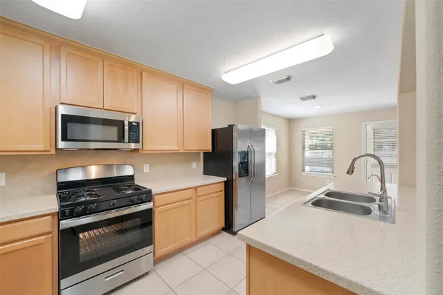 a kitchen with stainless steel appliances a stove microwave and refrigerator