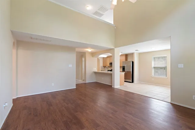 a view of an empty room with wooden floor