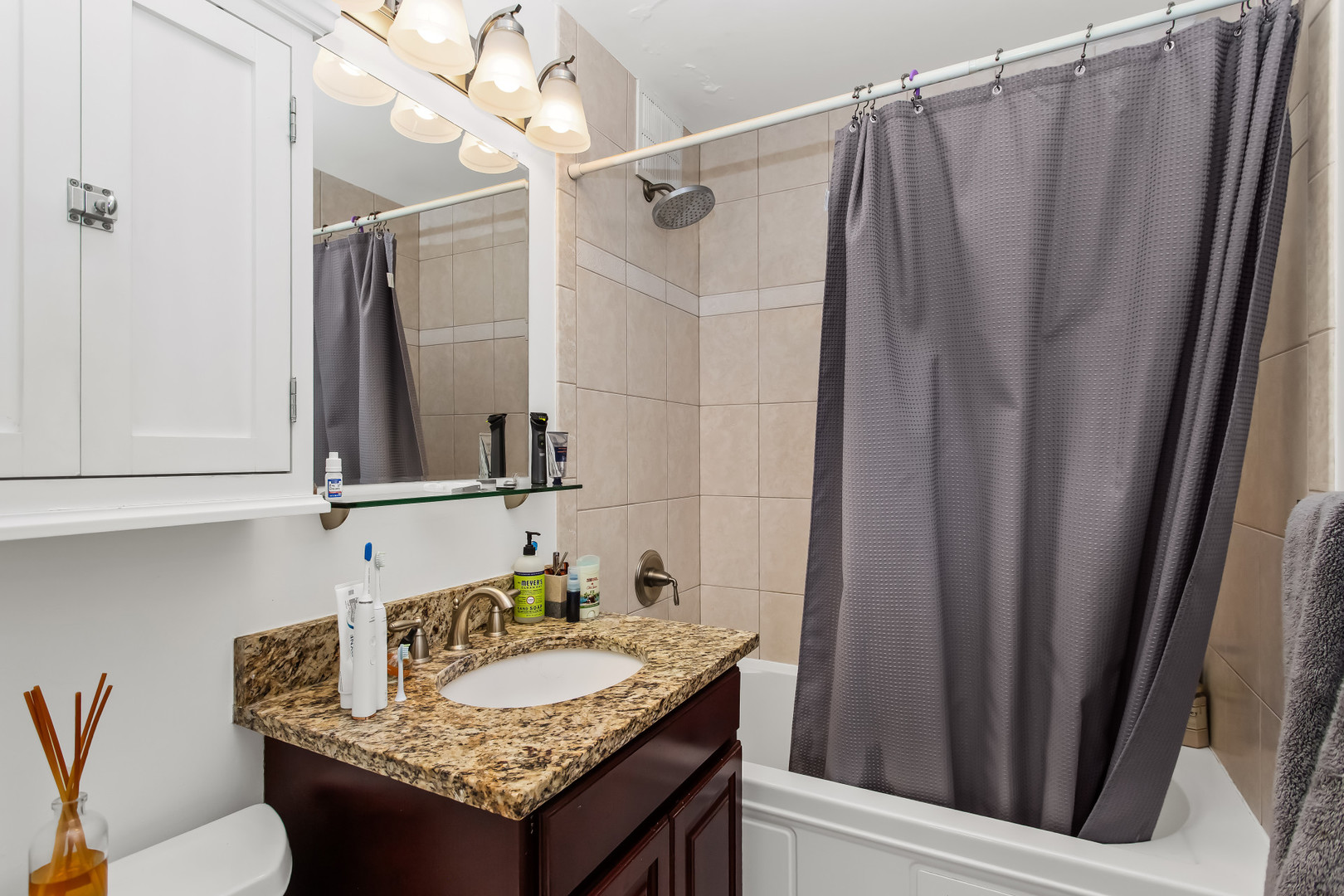 Undisclosed Address Chicago, IL 60613 - Photo 15 of 16 a bathroom with a granite countertop sink and a mirror